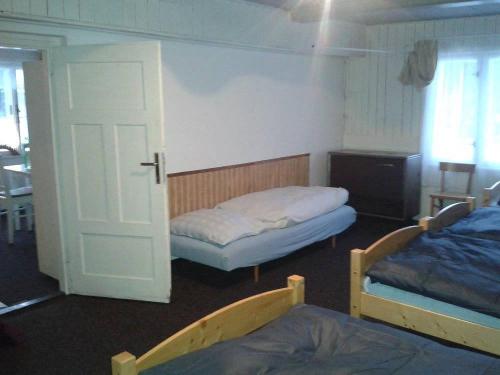a room with two beds and a door to a bedroom at Chata Čeřovský Harrachov in Harrachov