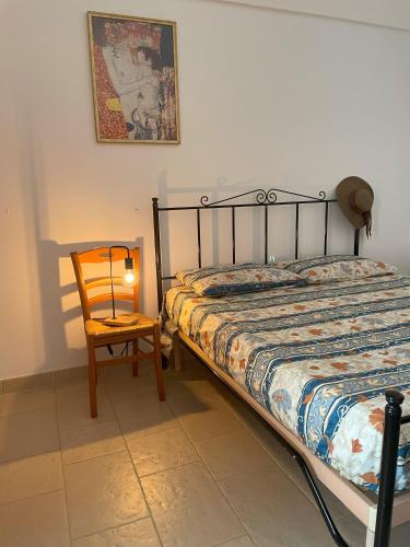 sypialnia z łóżkiem, krzesłem i lampką w obiekcie La Casetta di Lucia w Alberobello