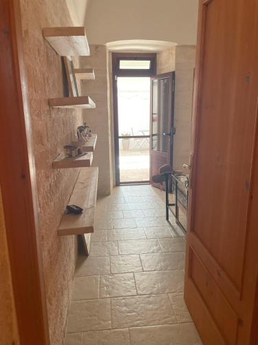 a hallway with a table and a door to a room at La Casetta di Lucia in Alberobello