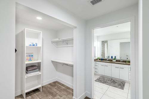a white kitchen with white cabinets and a mirror at Top Floor High Rise 3 Bed DTLA Skyscraper Penthouse in Los Angeles