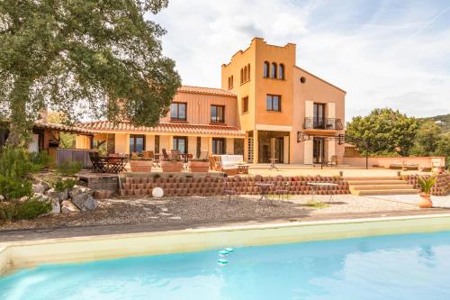 an exterior view of a house with a swimming pool at Mas la Marchette in Oms