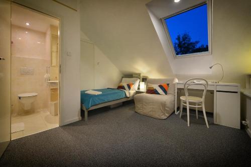 a small attic bedroom with a bed and a window at A. V. Pension Praha in Prague