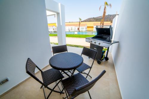a patio with a table and chairs and a grill at Pinares de Higuerillas in Maitencillo