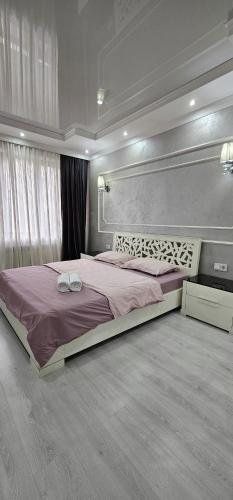um quarto com uma cama grande num quarto em Отличные апартаменты самом центре Алматы. Жилой комплекс Арбат em Almaty