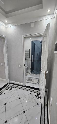 uma ampla casa de banho com um chuveiro e um espelho. em Отличные апартаменты самом центре Алматы. Жилой комплекс Арбат em Almaty