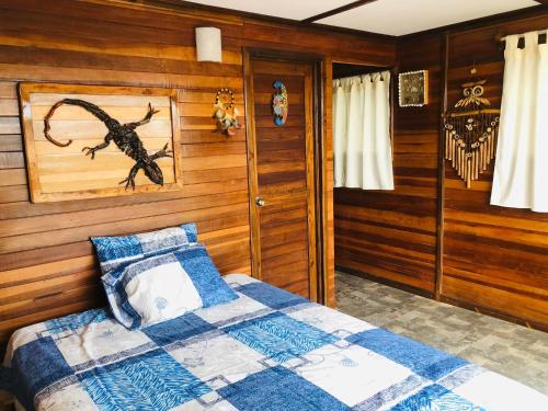 ein Schlafzimmer mit Holzwänden und ein Bett in einem Zimmer in der Unterkunft Casa Lobos in Lobitos