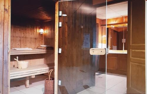 a shower with a glass door in a bathroom at T2 Les Chardons avec Piscine Sauna et Hammam in Valloire