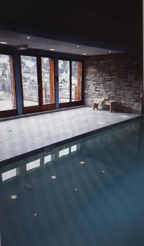 - une grande piscine dans une maison dotée de fenêtres dans l'établissement T2 Les Chardons avec Piscine Sauna et Hammam, à Valloire