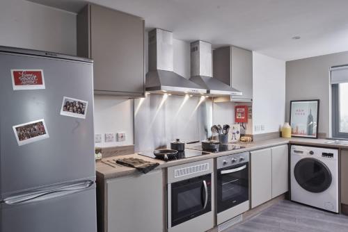 a kitchen with a refrigerator and a stove at Modern Ensuites with Shared Kitchen at Trinity View Student Accommodation in Coventry for Students Only in Coventry