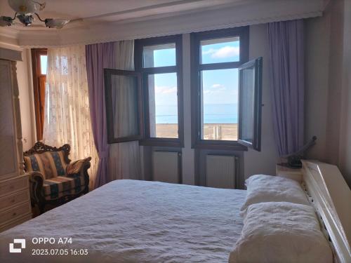 Schlafzimmer mit einem Bett und Strandblick in der Unterkunft Gündoğdu 