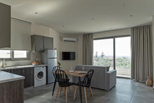a kitchen and living room with a table and chairs at Oliva Verde in Galatás