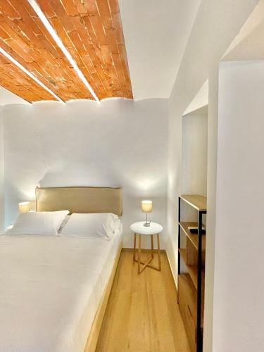 a bedroom with a white bed and a wooden ceiling at Hotel Tirreno in Marina di Massa