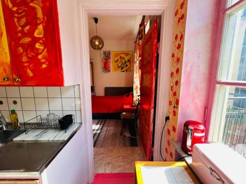 uma cozinha com uma porta vermelha e um sofá vermelho em The Sunset em Malmo