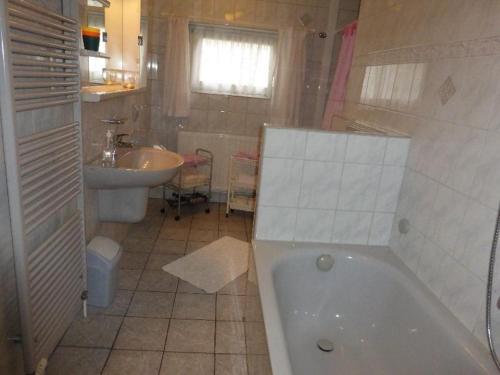 ein Badezimmer mit einer Badewanne, einem Waschbecken und einem WC in der Unterkunft Ferienwohnnung Westerwarft in Büsum