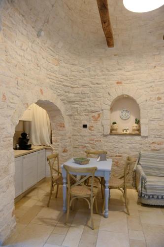 a kitchen and dining room with a table and chairs at Trullo A Casedd in Alberobello