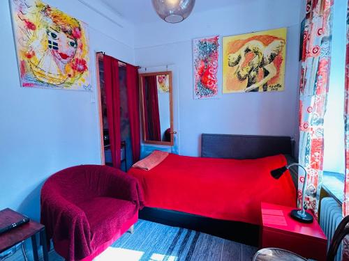 um quarto com uma cama vermelha e uma cadeira em The Sunset em Malmo