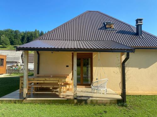 a small house with a porch with a swing at Vikendica Una in Kolašin