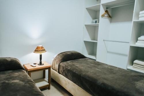 a room with two beds and a lamp on a table at Irová Apart Hotel in Posadas