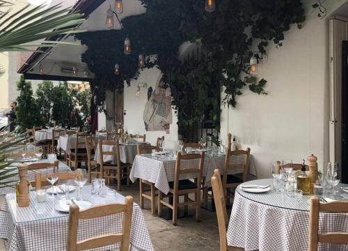 un restaurant avec des tables blanches, des chaises et des plantes dans l'établissement S11 2 Pièces cosy place - Balcony, à Nice