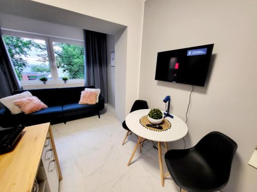 a small living room with a table and chairs at Mini Apartamenty Poznań in Poznań