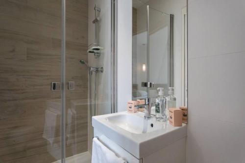une salle de bain blanche avec un lavabo et une douche dans l'établissement S11 2 Pièces cosy place - Balcony, à Nice