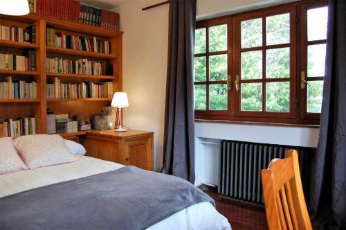 ein Schlafzimmer mit einem Bett und Bücherregalen mit einem Fenster in der Unterkunft Casa Vaqueiro Llanes in Llanes