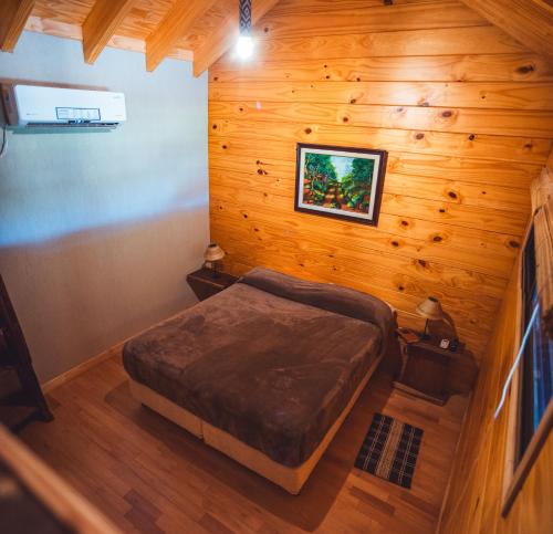 a bedroom with a bed in a wooden room at Irová Apart Hotel in Posadas