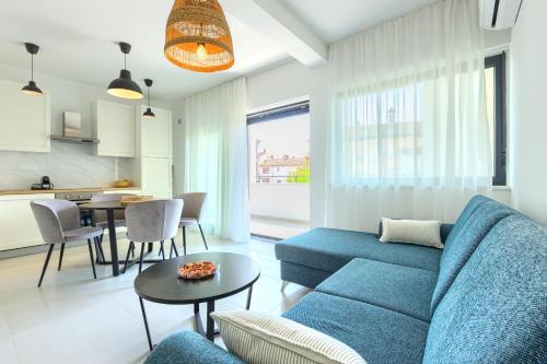 a living room with a blue couch and a table at Apartments La Scogliera Rovinj in Rovinj