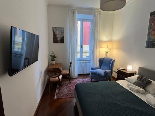 Schlafzimmer mit einem Bett, einem TV und einem Stuhl in der Unterkunft Torlonia Rooms in Rom