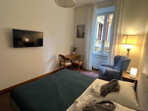 1 dormitorio con cama, mesa y TV en Torlonia Rooms en Roma