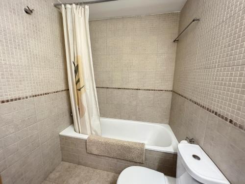 uma casa de banho com uma banheira, um WC e um lavatório. em Royal Marine II 136 - Piso con piscina comunitaria em Empuriabrava