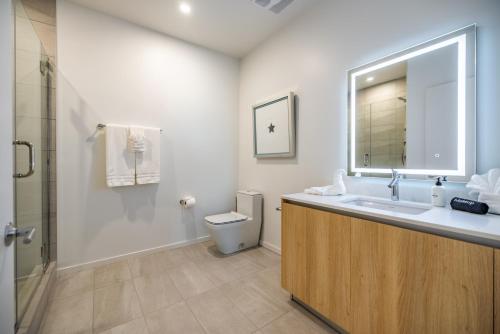 a bathroom with a sink and a toilet and a mirror at @ Marbella Lane - Luxury Beachside 2BR in Long Beach