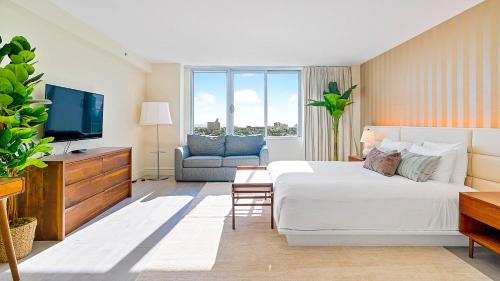 Cette chambre comprend un grand lit et une télévision. dans l'établissement 1100 West South Beach Luxe Miami Condos by Joe Semary, à Miami Beach