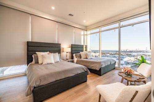 a bedroom with two beds and a large window at @ Marbella Lane - Luxury Beachside 2BR in Long Beach