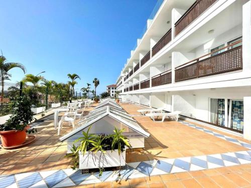 een lege binnenplaats van een gebouw met tafels en stoelen bij Apartamentos Pez Azul in Puerto de la Cruz