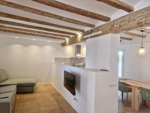 a kitchen and living room with white walls and wooden beams at Villa Barracot in Deltebre