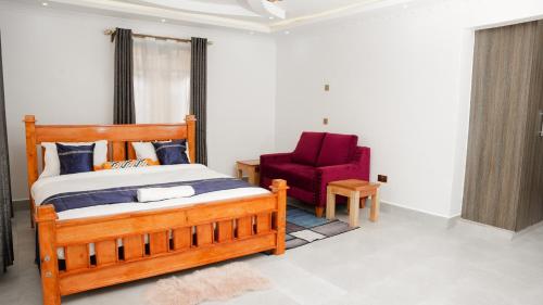 奈瓦沙的住宿－Advent Homes on Moi South lake road, Villa View Estate，一间卧室配有木床和红色椅子