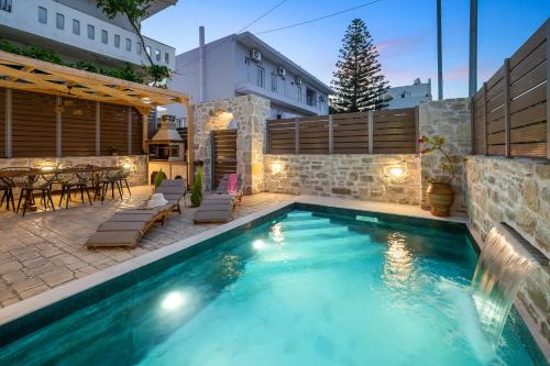 a pool with a patio and a table and chairs at Villa Privilege Kalamaki in Kalamaki Heraklion