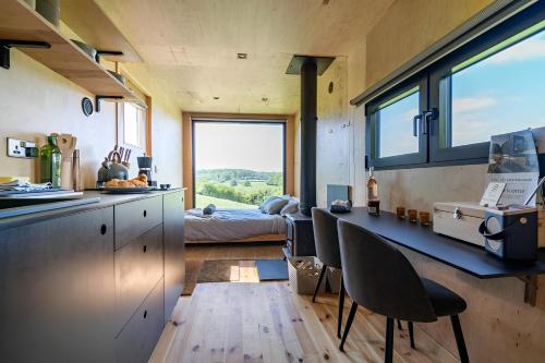 a kitchen with a table and chairs and a bedroom at Secluded Offgrid Cabin w/ Sunset View & Fireplace in Canterbury