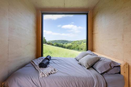 a bed in a room with a large window at Secluded Offgrid Cabin w/ Sunset View & Fireplace in Canterbury