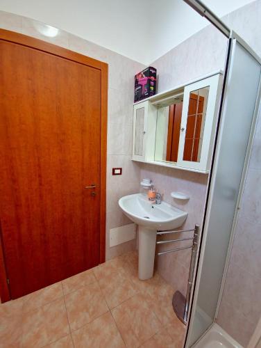 baño con lavabo y puerta de madera en Aglaia, en Torre Lapillo