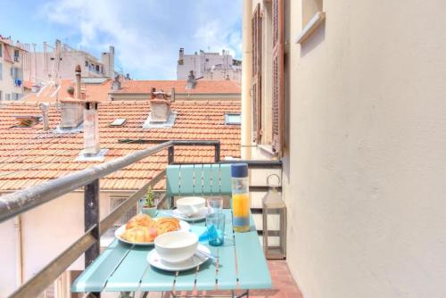 une table bleue avec une assiette de nourriture sur un balcon dans l'établissement S4 Studio Richelmi- AC Balcon 10mns Port 15mns Monaco, à Nice