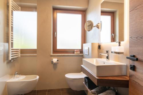 a bathroom with a sink and a toilet and a window at Apartments Karbon in Castelrotto