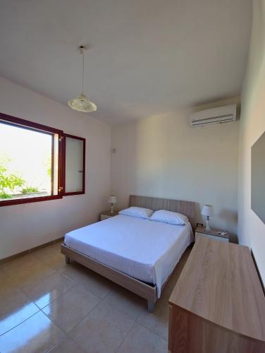a bedroom with a bed and a window and a table at Aglaia in Torre Lapillo