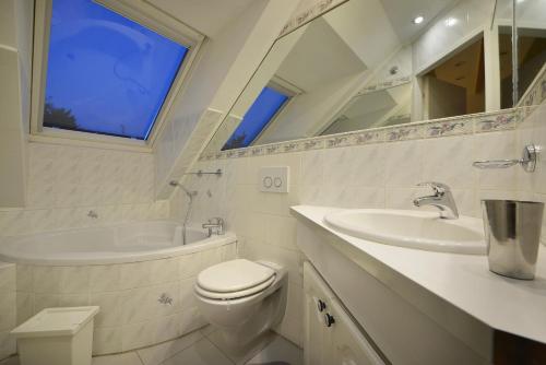 a bathroom with a toilet and a tub and a sink at A. V. Pension Praha in Prague