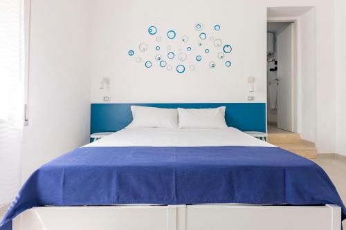 a bedroom with a blue and white bed and a clock at Dimora Terra di Puglia in Torre Santa Sabina