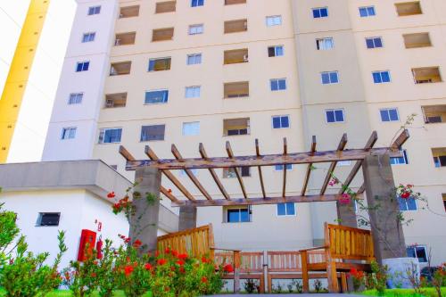 a building with a wooden pergola in front of it at Apartamento sofisticado, confortável e bem equipado - Loft Felau in Cuiabá