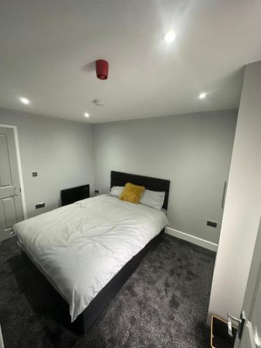 Thornaby on TeesにあるRoyal Apartmentsのベッドルーム(白い大型ベッド、黄色い枕付)