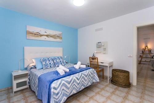 ein Schlafzimmer mit einem Bett, einem Schreibtisch und einem Stuhl in der Unterkunft Eslanzarote TANA HOUSE, super wifi, Tv satélite, Bbq in Playa Honda