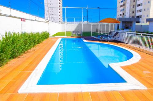 a swimming pool with blue water in a building at Apartamento sofisticado, confortável e bem equipado - Loft Felau in Cuiabá